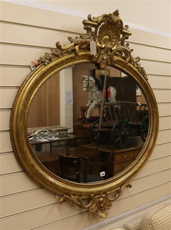 A late Victorian oval giltwood and gesso wall mirror W.108cm